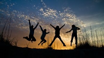 A silhouette of a group of jumping friends