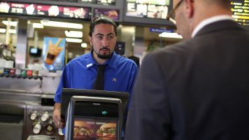 A McDonald's employee takes a customer's order