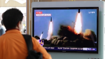 Passerby watch coverage of a North Korean missile launch