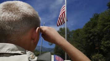 A Boy Scout salutes the American flag.