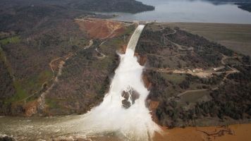 Oroville lake, the emergency spillway, and the damaged main spillway, are seen from the air.