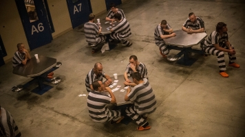 Prison inmates sit at tables
