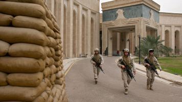 U.S. Marines walk past the front of the American Embassy in Baghdad, Iraq.