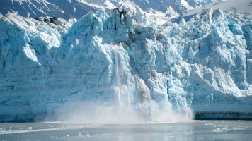 Part of glacier breaking off and falling into the ocean