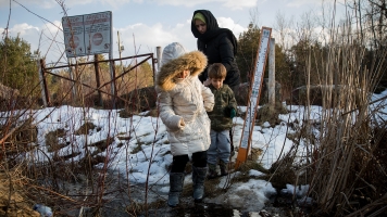 A family from Turkey crosses the U.S.-Canada border into Canada