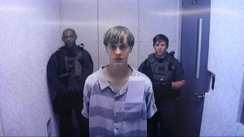 Dylann Roof stands during a video conference.