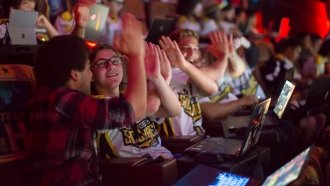 Teammates high-five during a Super League Gaming Tournament
