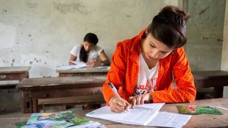 A Nepali teenage girl writes down her story.