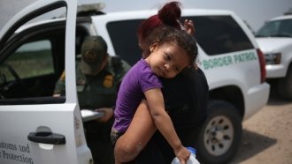 A mother and 3-year-old child from El Salvador await transport to a processing center for undocumented immigrants.