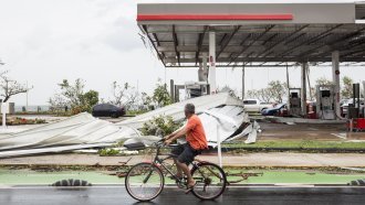 A man looks at storm damage from Hurricane Maria