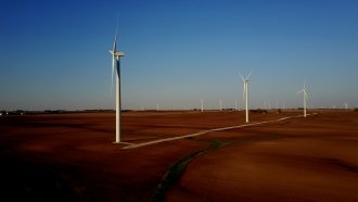 Wind turbines turn above cornfields in rural Iowa