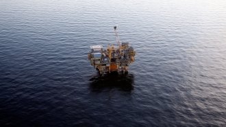 An offshore oil rig sits in the ocean