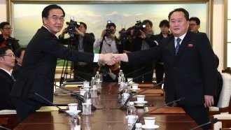 South Korea's unification minister shakes hands with the head of North Korean delegation.