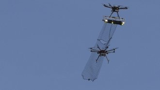 A drone helicopter captures another drone helicopter in a net