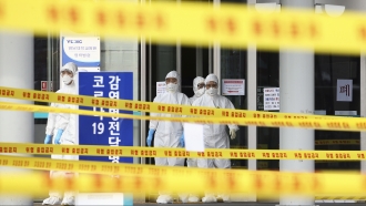 Medical staff in protective suits outside Korean hospital