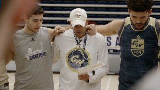 George Washington University basketball coach Jamion Christian stands with players