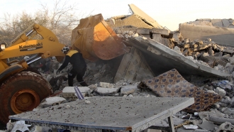 Aid workers dig through rubble