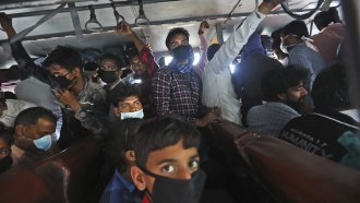 Migrant daily wage laborers crowd a bus in India.