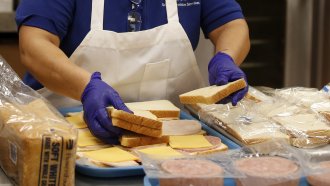 Kitchen assistant Maria Cedillo makes sandwiches for lunch bags.