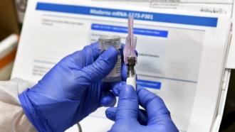 A nurse prepares a Moderna COVID-19 vaccine shot during clinical trials.