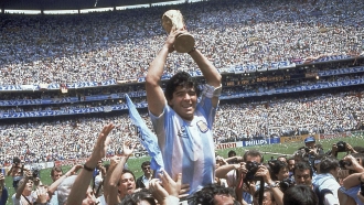 Diego Maradona holds up his team's trophy after Argentina's 3-2 victory over West Germany at the World Cup final.