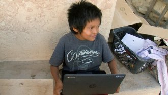 Seven-year-old Jaydon Zeema of the Hopi Tribe in Arizona on the laptop provided by his school.