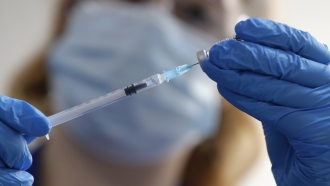 nurse prepares a shot of Pfizer COVID-19 vaccine