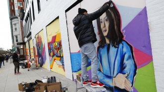 Shawn Perkins spraypaints a mural of Kamala Harris