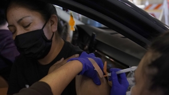 Jamie Yeini receives a shot of the Moderna COVID-19 vaccine at a drive-thru vaccination center in California.