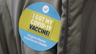 A person wears a sticker after they were given the first of two doses of the Pfizer vaccine.