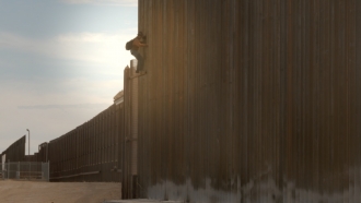 A man scales the border wall in El Paso