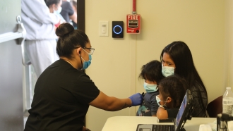 Migrant family is given an initial health screening at a border patrol facility.