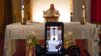 Pastor Nicolas Sanchez is seen on his iPhone used to live-stream