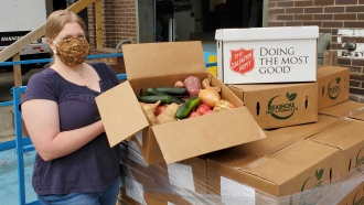A Food Rescue Hero volunteer fills up boxes of produce for delivery