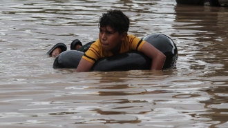 A child floats on an inner tube in a flooded street in the aftermath of Hurricane Eta inHonduras, Friday, Nov. 6, 2020