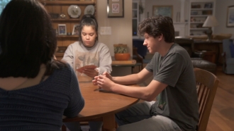 Teens sit at a table