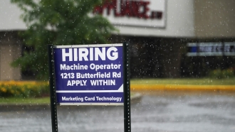 A hiring sign is displayed in Downers Grove, Ill.