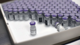 Frozen vials of the Pfizer/BioNTech COVID-19 vaccine are taken out to thaw.
