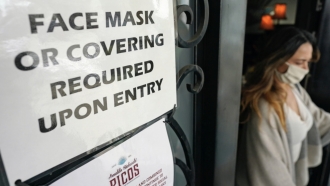 Sign reminds people to wear masks.