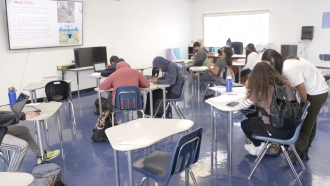 Students work in a classroom.