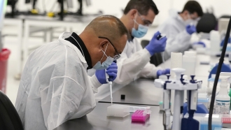 Technicians conduct COVID-19 tests at a facility