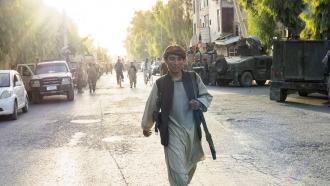 An Afghan soldier walks down the street in Kandahar as the Afghan Armed forces retreated