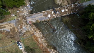 A flood-damaged bridge spans the Pigeon River