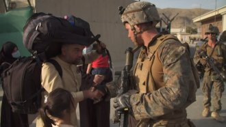 Soldier shakes a man's hand.