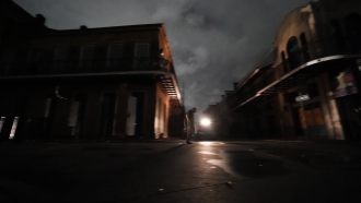 A man walks down Bourbon Street after the city lost power in the aftermath Hurricane Ida in New Orleans