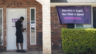A security guard opens the door to the Whole Women's Health Clinic in Fort Worth, Texas.