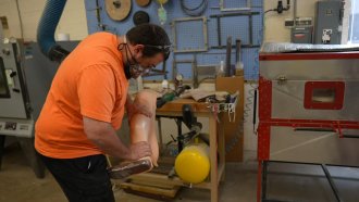 Man works on a prosthetic leg.