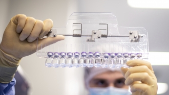 A technician inspects filled vials of the Pfizer-BioNTech COVID-19 vaccine at the company's facility in Puurs, Belgium