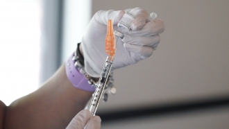 A nurse loads a syringe with the Pfizer COVID-19 vaccine.