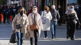 Shoppers wearing face masks walk on Oxford Street in central London.